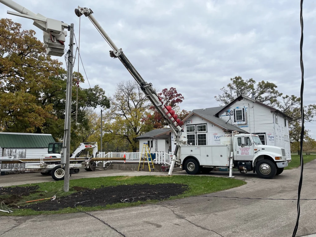 Cullen Enterprises of Wisconsin truck with bucket working on residential electric pole at clients house